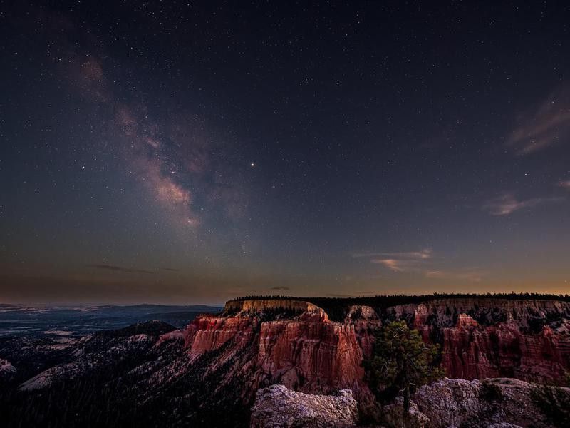 Night sky with dark milky way starscape in Bryce Canyon National Park in Utah at Pariah view overlook and rock formations panoramic viewpoint