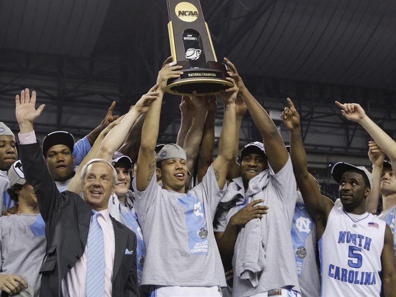 North Carolina coach Roy Williams and players hold up trophy