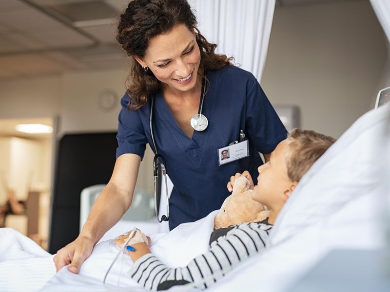 Nurse taking care of a child hospitalized in bed