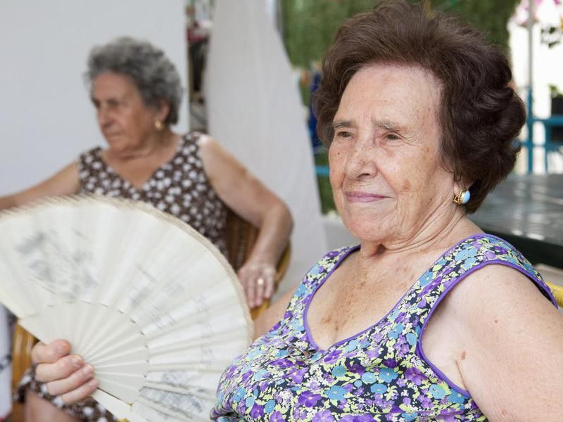 Older woman fanning herself outdoors