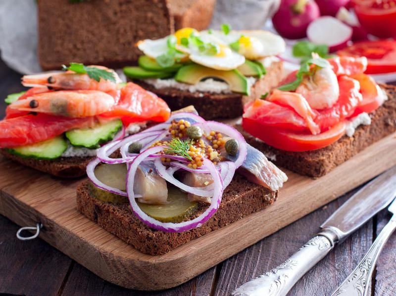 Open sandwich with salted herring, cucumber, red onion, mustard on rye bread