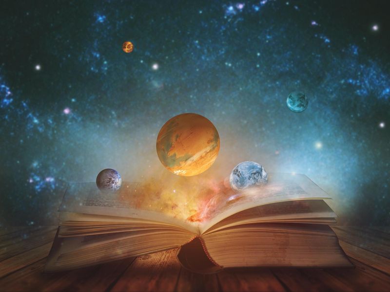 opened magic book with planets and galaxies