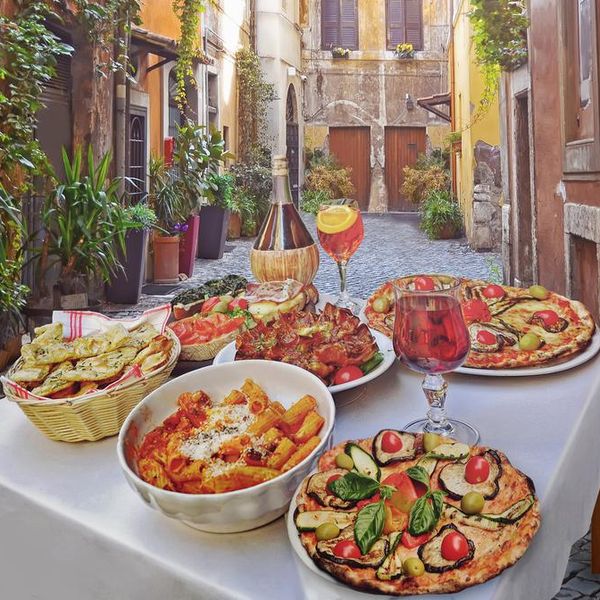 A summer  dinner .Pasta , pizza  and homemade food arrangement  in a restaurant  Rome   .Tasty and authentic Italian food.