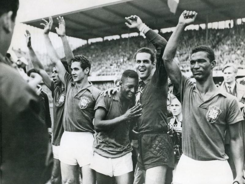 Pele celebrates with other Brazil players at the 1958 World Cup