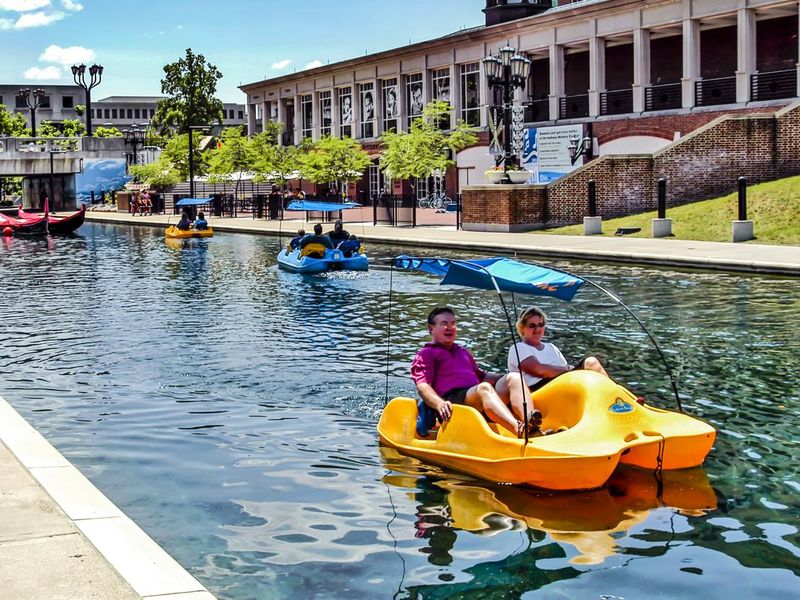 People riding in boats in the Central Canal in the University and Arts district of Indianapolis, IN