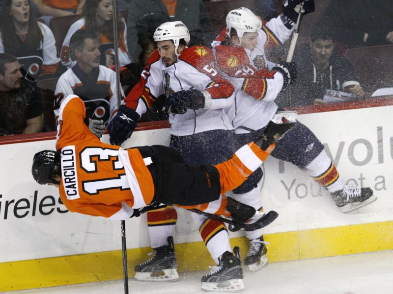 Philadelphia Flyers' Daniel Carcillo gettig checked into boards