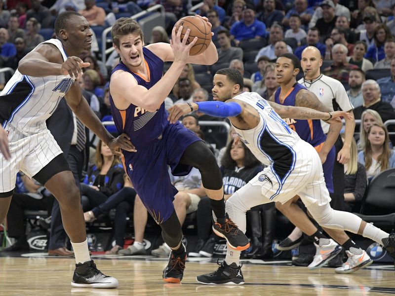 Phoenix Suns forward Dragan Bender drives between Orlando Magic center Bismack Biyombo and guard D.J. Augustin