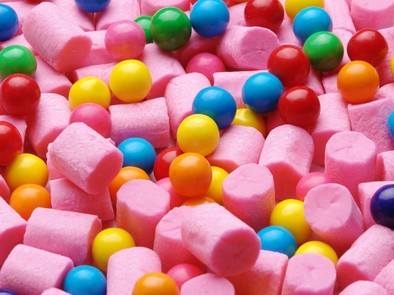 Pink cylinder-shaped gum and colorful gumballs