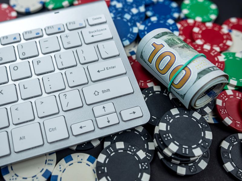 Poker chips for poker with money and a laptop keyboard