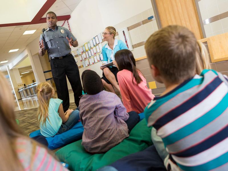 Police or school security officer speaking to young students