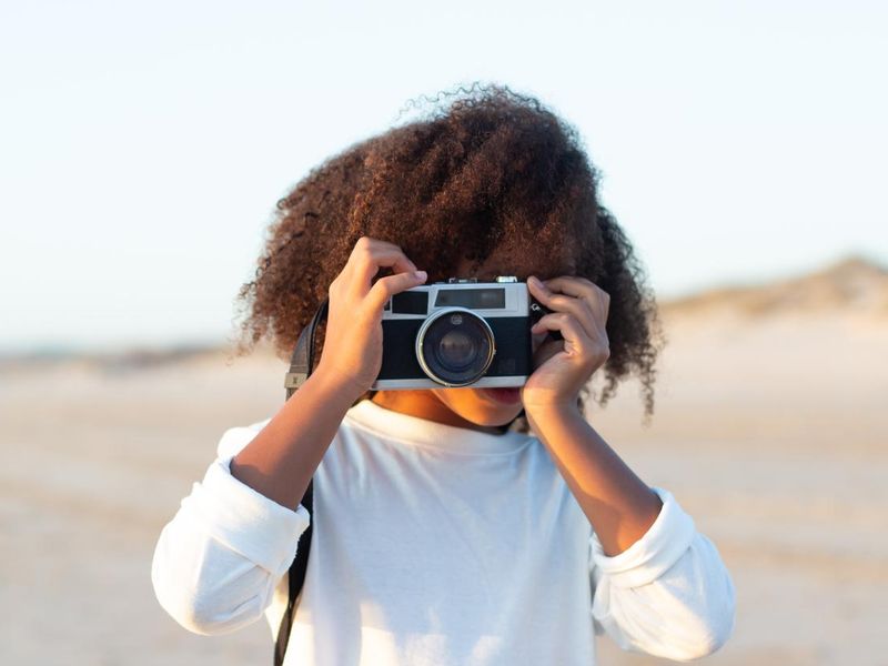 Portrait of cute girl with old-fashioned camera