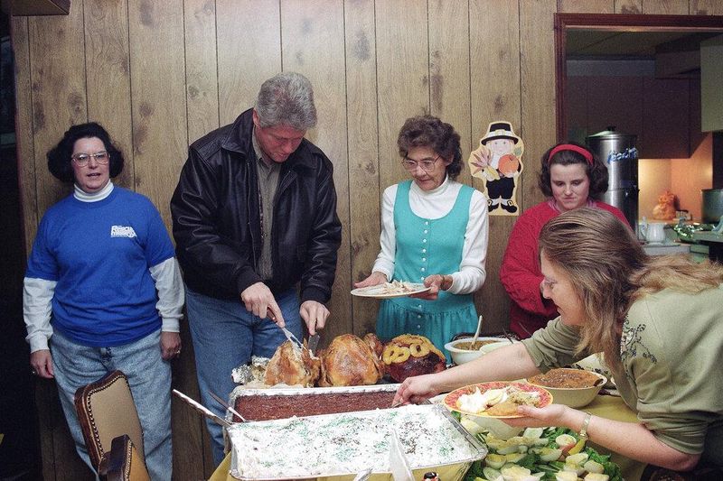 President-elect Bill Clinton slices Thanksgiving turkey at Dorcas House, a shelter for battered and abused women and their children