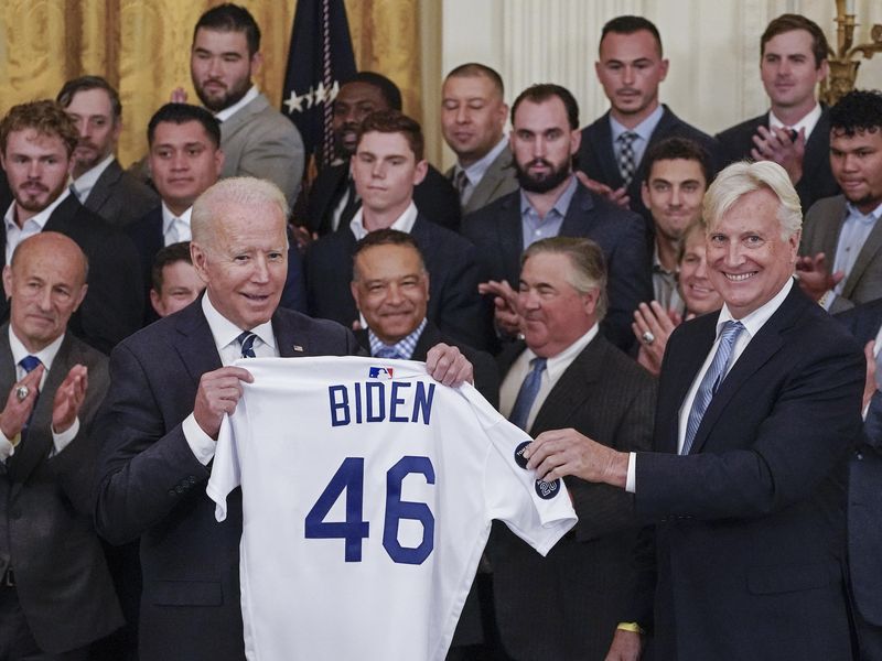 President Joe Biden receives a jersey from Los Angeles Dodgers co-owner Mark Walter