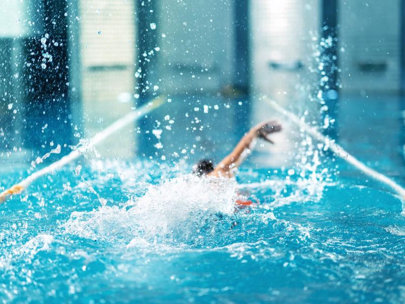 Professional swimmer doing exercise in indoor swimming pool