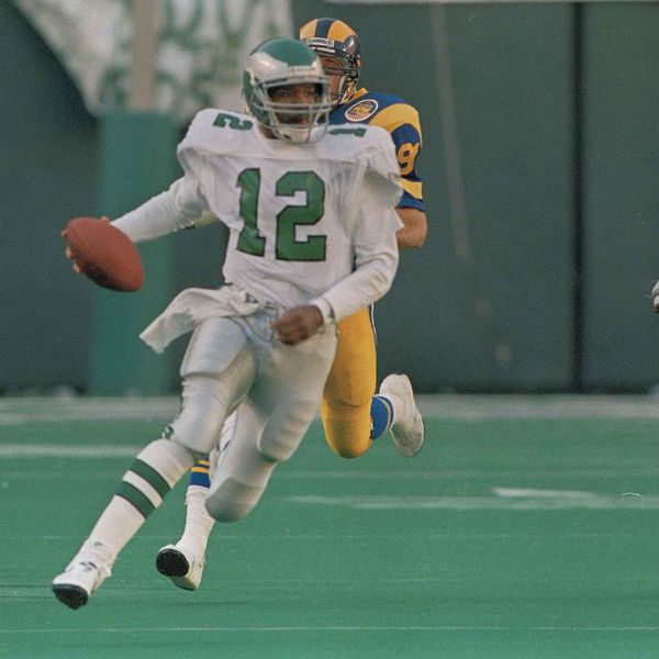 Philadelphia Eagles quarterback Randal Cunningham highsteps his way to an eighteen yard gain and a first down at Los Angeles Rams' Fred Strickland tries to tackle him during third quarter NFL action at Philadelphia's Veterans Stadium, Nov. 6, 1988. (AP Photo/Rusty Kennedy)
