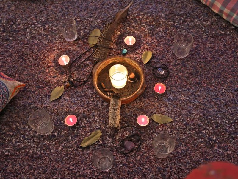 Raw cacao set with flowers candles, feathers, Palo Santo, bay leaves, and pillows for the shamanic ceremony