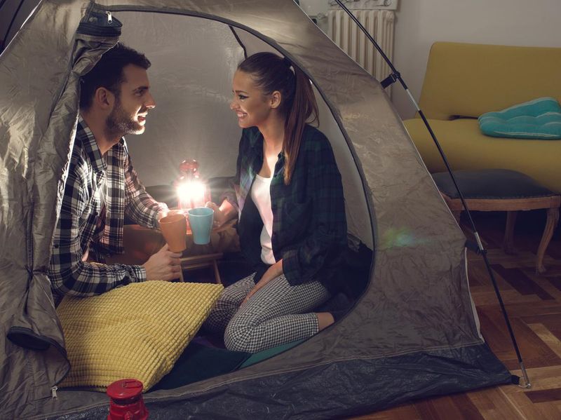 Romantic couple talking to each other during camping at home.