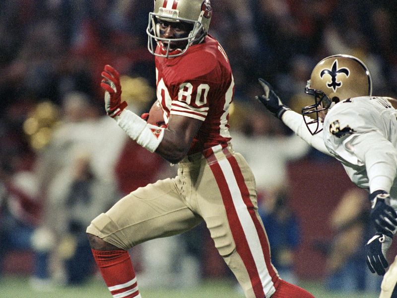 San Francisco 49ers wide receiver Jerry Rice runs past New Orleans Saint Toi Cook