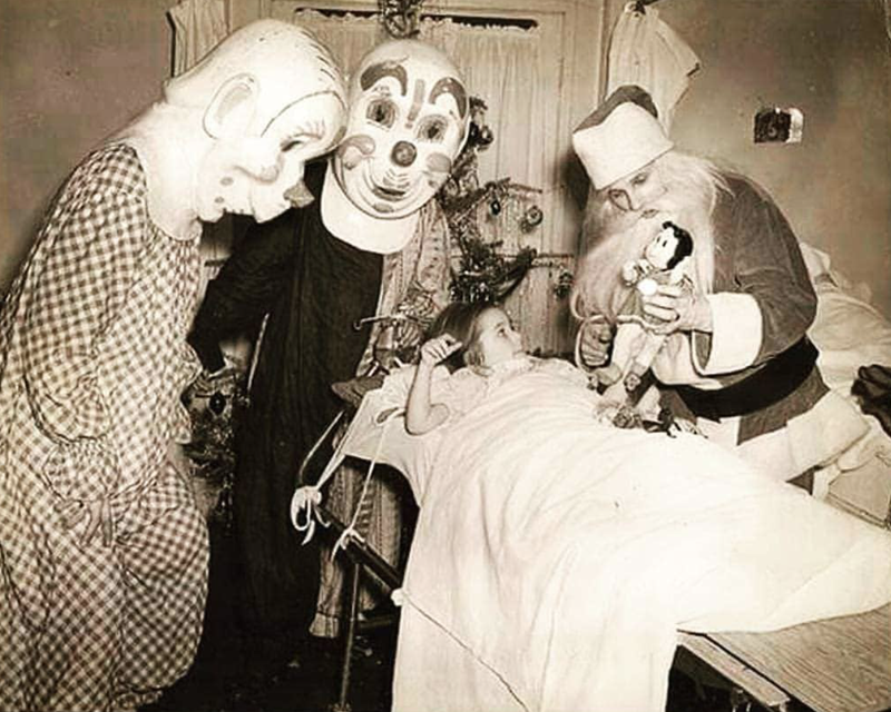 Santa Claus and Christmas clowns visiting a sick child in hospital