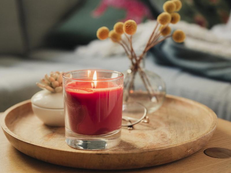 Scented candle burning on sofa table