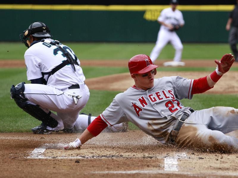 Seattle Mariners catcher Miguel Olivo waits for ball as Los Angeles Angels' Mike Trout scores