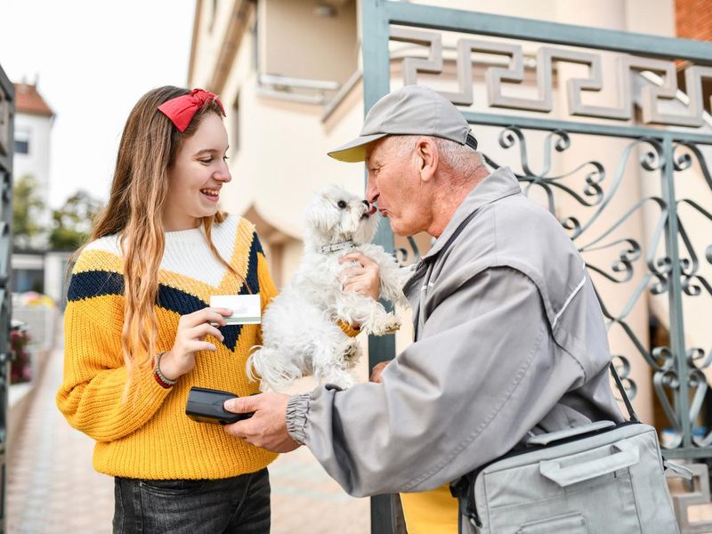 Senior Mailman Kissing Small Puppy