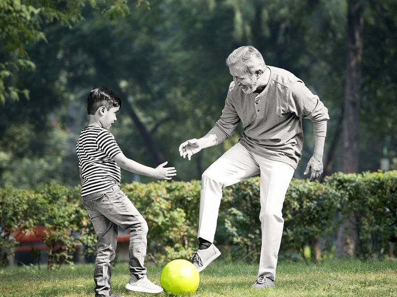Senior man playing with grandson at park