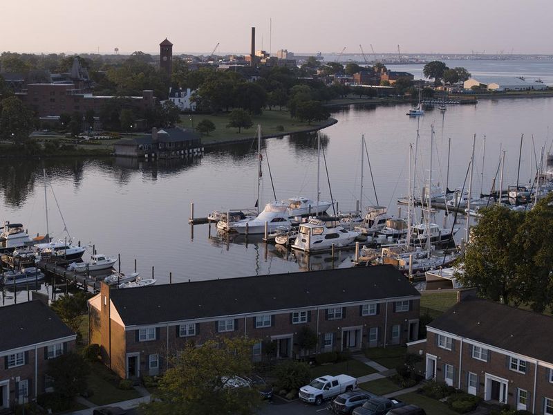 Serene morning at Salters Creek neighborhood by Marina. Pier with yachts on Hampton River, VA in early morning glow. Aerial view