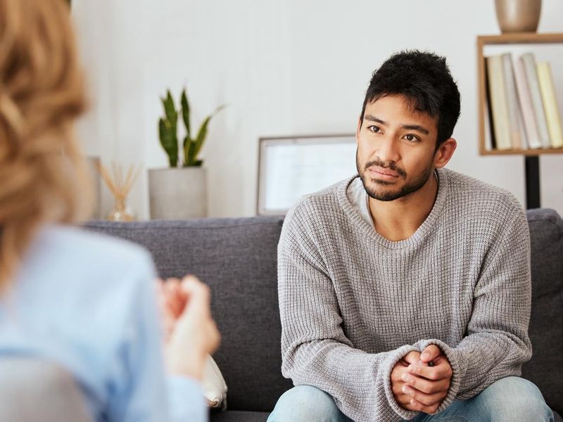 Shot of a young man having a therapeutic session with a psychologist