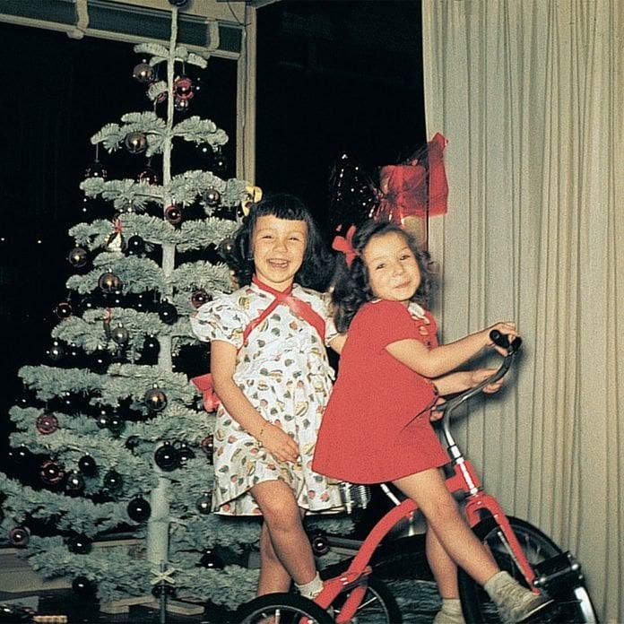 Sisters and their bike around the Christmas tree