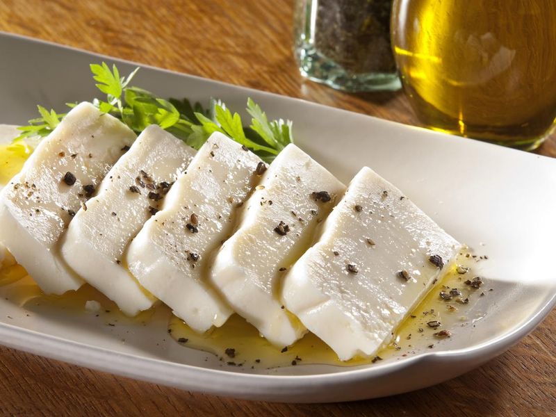 Sliced Turkish feta cheese with olive oil and herb garnish