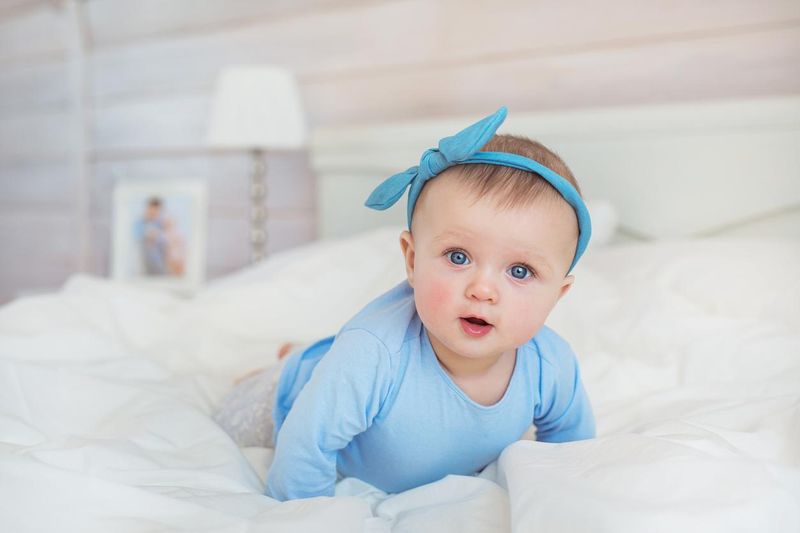Smiling infant crawling on a bed