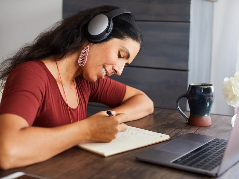 Smiling woman listening to music while working from home