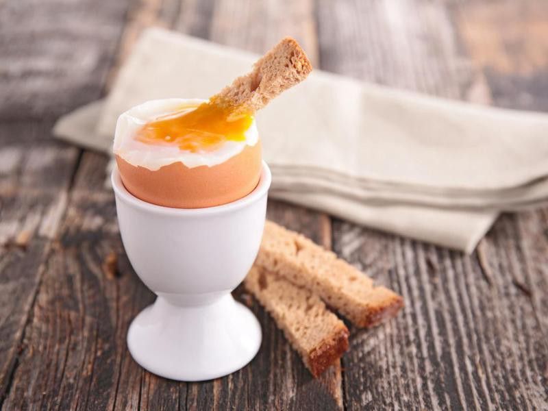 Soft boiled egg being served with slices of bread