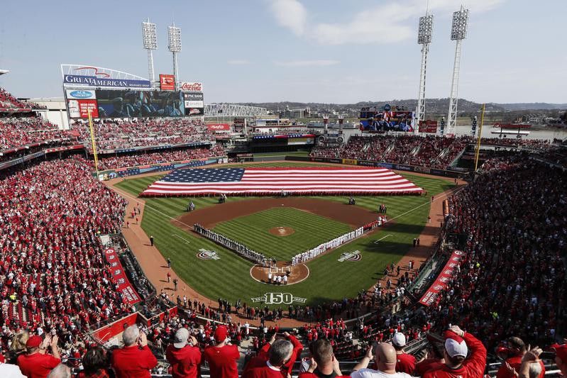 Spectators stand for the national anthem before Opening Day