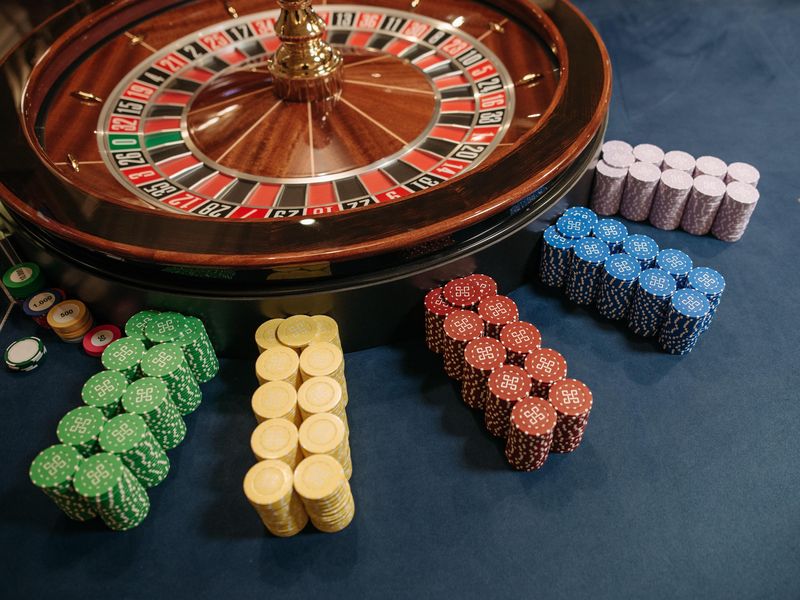Stacked poker chips beside roulette wheel
