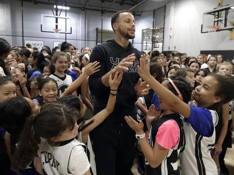 Steph Curry with kids at a basketball camp