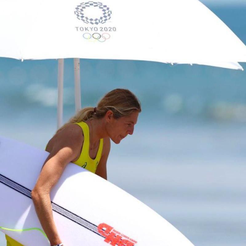 Stephanie Gilmore under umbrella with surfboard