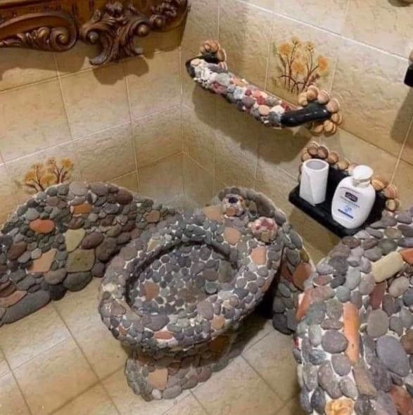 Stone toilet, sink, and decor in bathroom