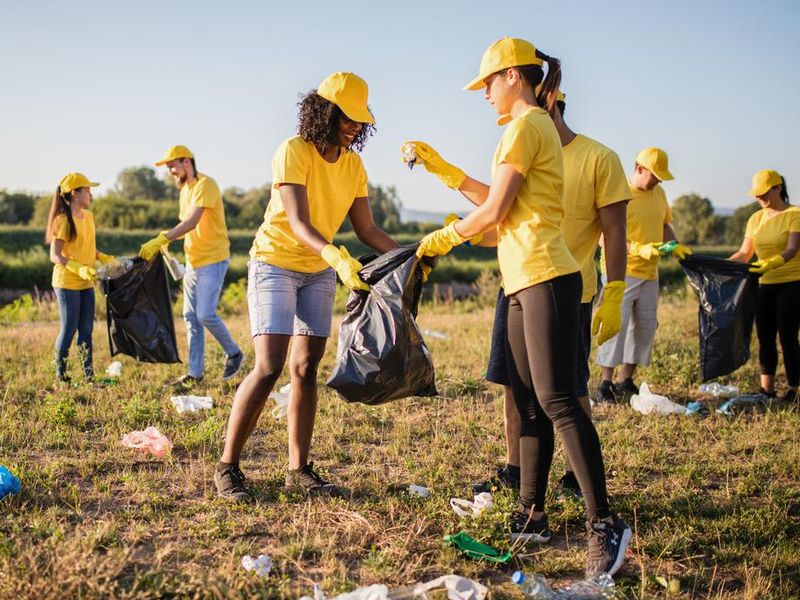 Student volunteers picking up trash in a park