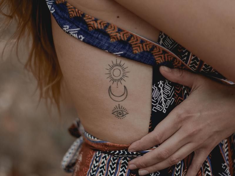 Sun, Moon, and Eye Tattoos on Ribcage