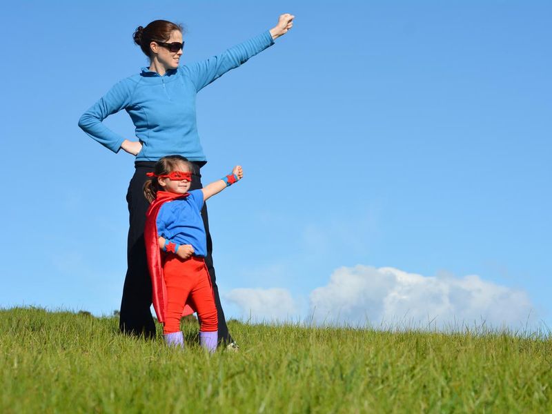 Superhero mother and child show off girl power