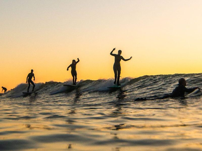 Surfers in the Ocean at Sunset