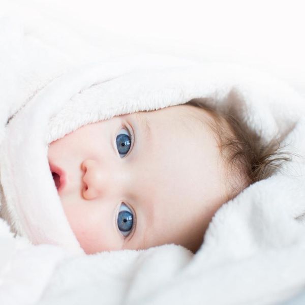 Sweet baby with blue eyes playing peek-a-boo