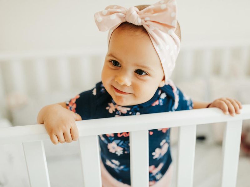 Sweet little baby standing in crib