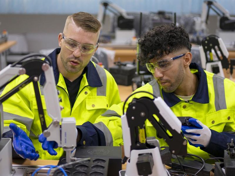 Technicians work with robotic arm