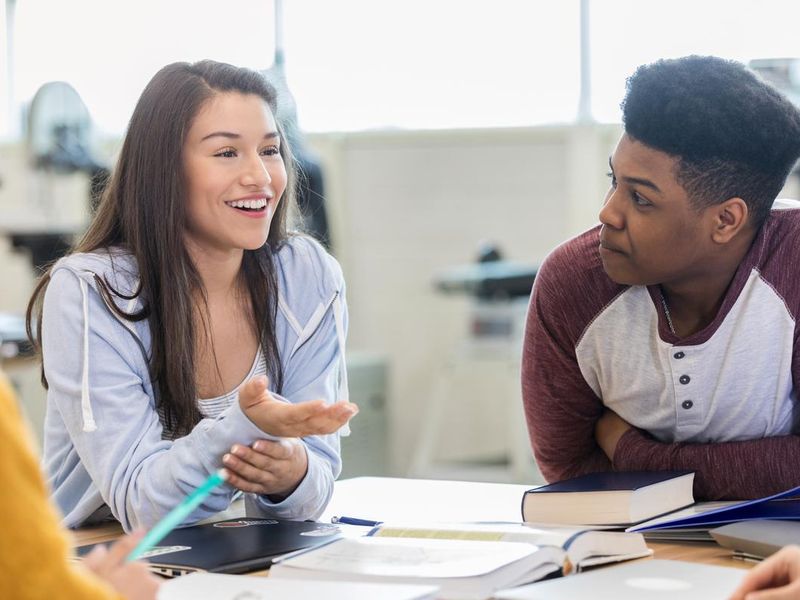Teen girl debates with peers in class