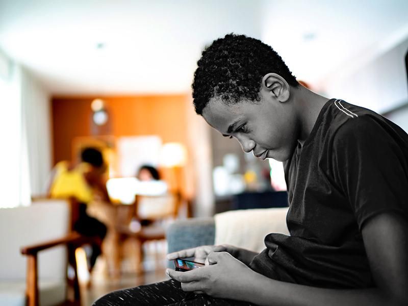 Teenager boy using smartphone at home
