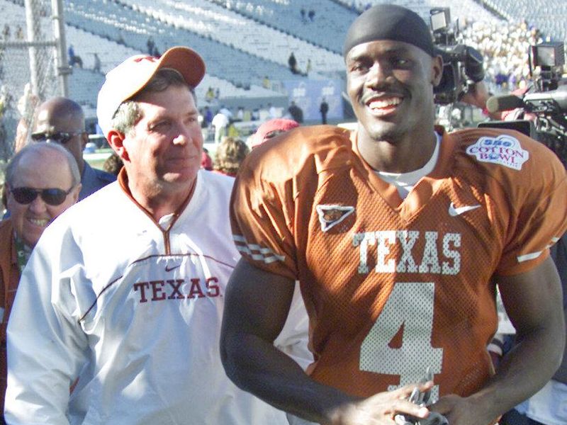 Texas coach Mack Brown, left, walks off the field with wide receiver Roy Williams