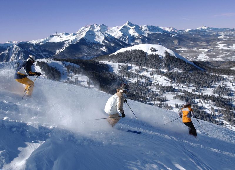 Three friends skiing fresh powder